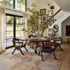 a dining room table with four chairs and a rug on the floor in front of it