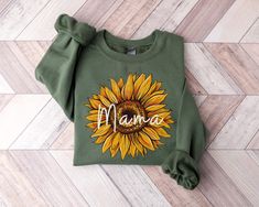 Mama Sunflower Sweatshirt *Product Details * Unisex Sweatshirt * Created with pre-shrunk air-jet spun yarn * Crew Neck * Double-needle stitched collar, shoulders, armholes, cuffs, and hems * Loose fit for comfort *Fabrication * 50% Cotton, 50% Polyester *Care * Machine wash inside out, cold water on delicate cycle * Dry on low heat setting * Do not bleach * Do not iron design directly *Shipping & Processing * Processing/fulfillment time is 2-10 days * Standard shipping takes 3-5 days * Please note that these times are estimated by the carrier and may take longer * Please verify your shipping address is correct before placing your order *Disclaimer * Colors in listings may vary slightly depending on your device * Prints may appear smaller depending on the shirt size ordered * Please contact Green Long Sleeve Tops For Mother's Day, Green Mama Sweatshirt, Sunflower Sweatshirt, Crew Neck Cotton T-shirt With Sunflower Design, Casual Sunflower Design Crew Neck T-shirt, Mother's Day Screen Print Crew Neck T-shirt, Floral Print Crew Neck T-shirt For Mother's Day, Thanksgiving Sweater, Mothers Day Gift Ideas