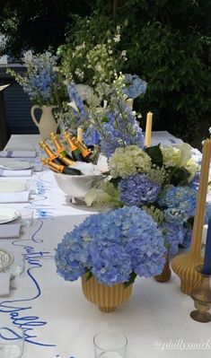 the table is set with blue and white flowers