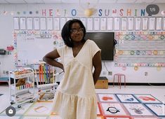 a woman standing in front of a blackboard with lots of magnets on it