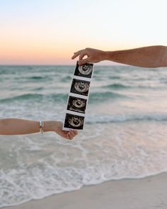 two people holding out their hands to each other on the beach