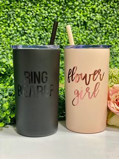 two tumblers with straws sitting next to each other on top of a table