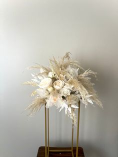 a white flower arrangement in a gold stand