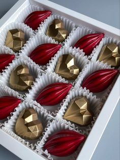 there are many chocolates in the box with red and gold decorations on it's sides