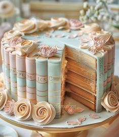 a cake decorated with books and flowers on a table