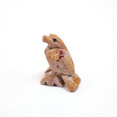 a small figurine of a bird on a white background