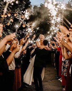 a bride and groom are surrounded by sparklers