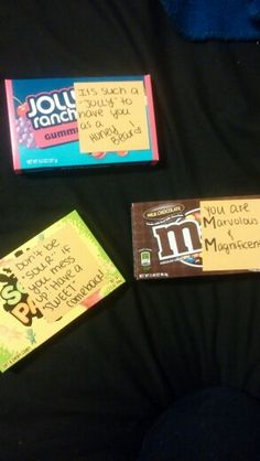 three pieces of candy sitting on top of a black table next to each other with notes written on them