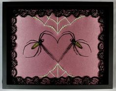 two large black spiders in a heart - shaped frame on a pink and black background