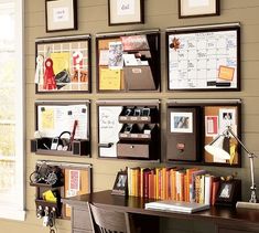 a home office with red walls and lots of pictures on the wall, including a desk