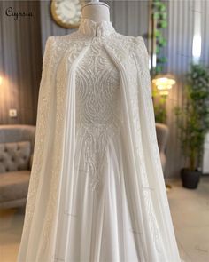 a white wedding gown on display in a room