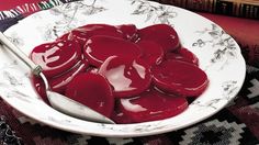 a white bowl filled with red jelly sitting on top of a table next to books