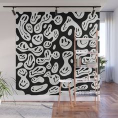 a black and white abstract painting on a wall in a room with wooden flooring