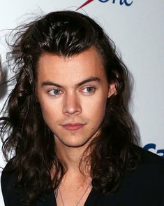 a close up of a person with long hair and a black shirt in front of a white background