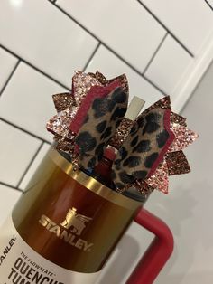 a can with some hair clips on top of it in the shape of a leopard print bow