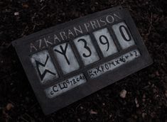 the license plate for azkaban prison lies on the ground in dirt and mulch