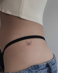 a woman's stomach with a small butterfly tattoo on the side of her belly