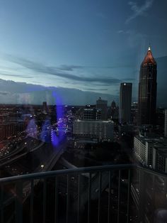 the city skyline is lit up at night with blue lights and buildings in the background