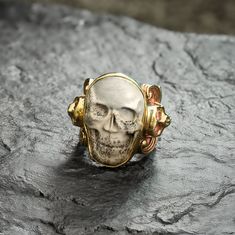 Discover the allure of the Carved Skull Ring, featuring hand-carved human skulls in Horn, Bone and Jasper. Set in our traditional Sylvan Band with intricate floral motifs and mini skulls on the edges, this limited-edition vintage piece won't be restocked-ideal for collectors seeking bold, one-of-a kind designs.