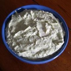 a blue bowl filled with cream cheese on top of a wooden table