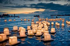 many floating lanterns in the water with a quote on it that says we live in a wonderful world that is full of beauty, charm and adventure