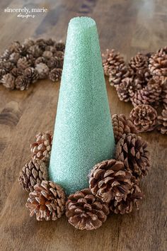 a pine cone with some cones around it on a wooden table next to other pine cones