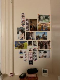 a white wall with many pictures on it and a phone in front of the door