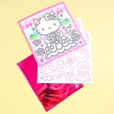 two hello kitty greeting cards sitting on top of each other next to pink envelopes