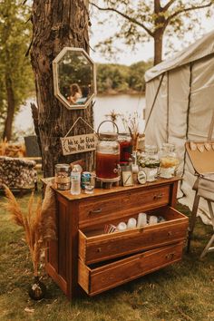 an old dresser with jars on it in front of a tree and the words, there are