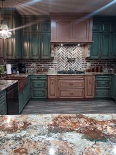 a kitchen with green cabinets and marble counter tops