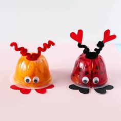 two plastic ladybugs with hearts and antlers on their heads sitting next to each other