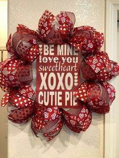 a red and white valentine's day wreath with the words be mine, love you sweetheart xoxo cutie pie