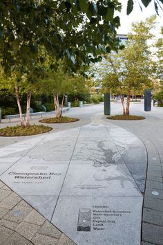 there is a memorial in the middle of this walkway that has trees and bushes around it