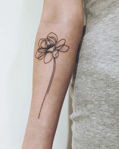 a woman's arm with a flower tattoo on the left side of her arm