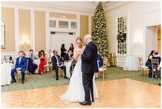 a bride and groom dance together in front of a christmas tree at their wedding reception