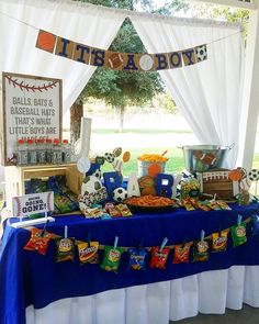 a baseball themed dessert table under a tent at a sports birthday party with decorations and food