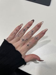 a woman's hand with stars painted on it and her nails in the shape of stars