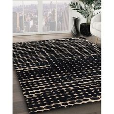 an area rug with black and white designs on it in front of a large window