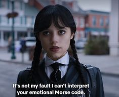 a woman with braids wearing a suit and tie in front of a city street