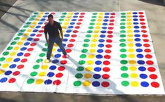 a man standing on top of a giant colored dot covered area next to a sidewalk