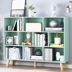 a green bookcase with books and pictures on it