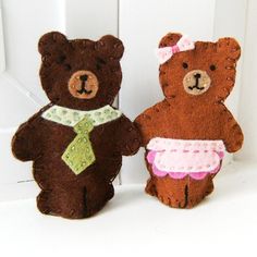 two brown teddy bears dressed in pink and green