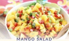 mango salad in a white bowl with a wooden spoon on the side that says mango salad