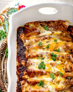 a casserole dish with meat, cheese and parsley in it on a table