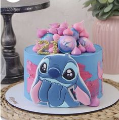 a blue and pink cake sitting on top of a table