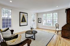 a living room with hardwood floors and white walls