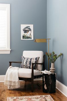 a living room with blue walls and white furniture