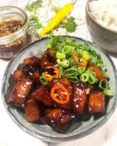 a plate filled with meat and veggies next to a bowl full of rice