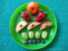 a green plate topped with fruits and vegetables