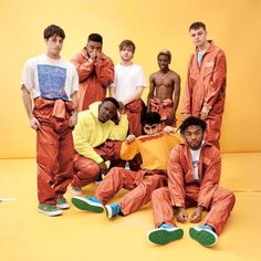 a group of young men in orange outfits posing for a photo with green shoes on